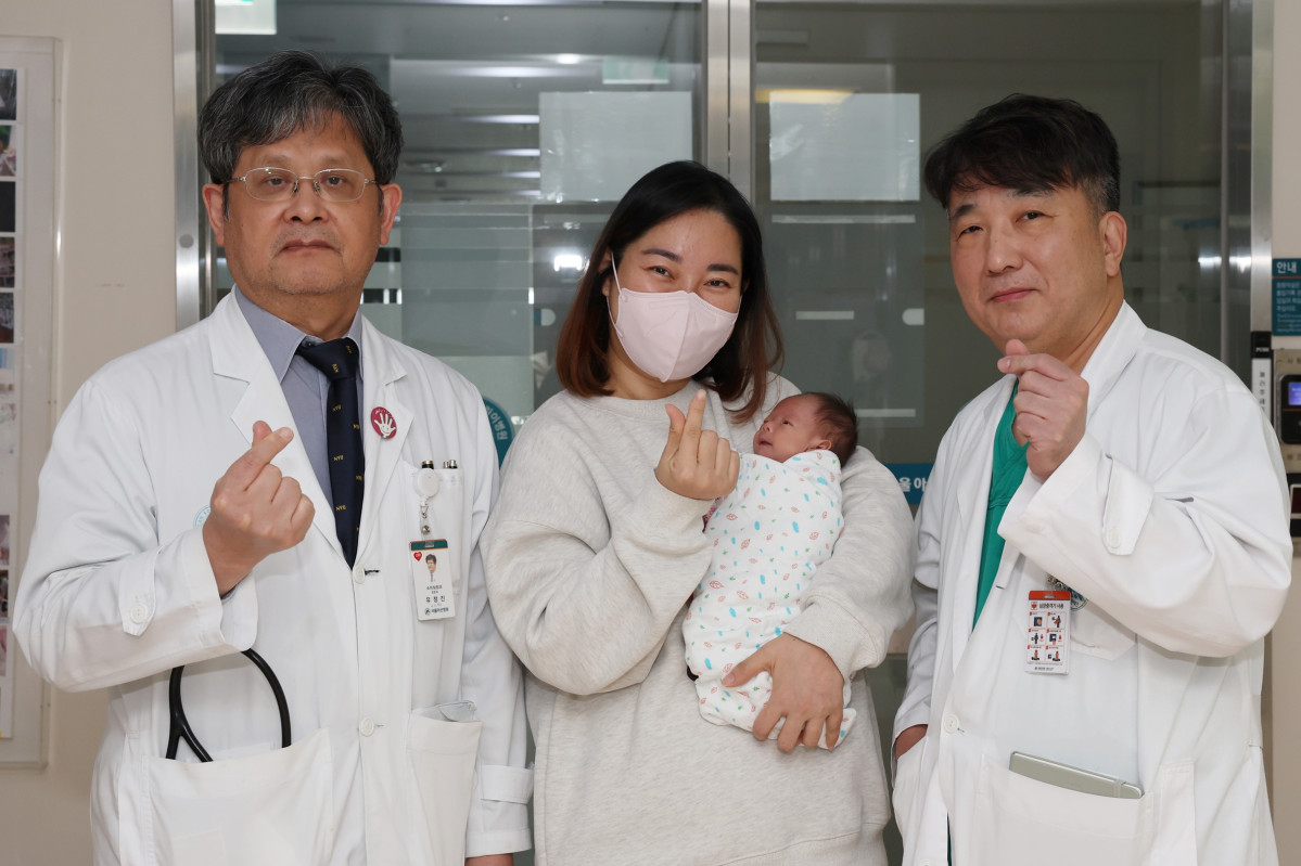 ▲서울아산병원은 심장 크기가 엄지손가락만한 저체중아의 복잡한 선천성심장병을 생후 8일 만에 치료하는 데 성공했다. (왼쪽부터) 유정진 서울아산병원 선천성심장병센터장, 이준이 어머니와 이준이, 수술을 집도한 윤태진 서울아산병원 소아심장외과 교수가 이준이의 퇴원을 앞두고 기념 촬영을 하고 있다. (사진제공=서울아산병원)