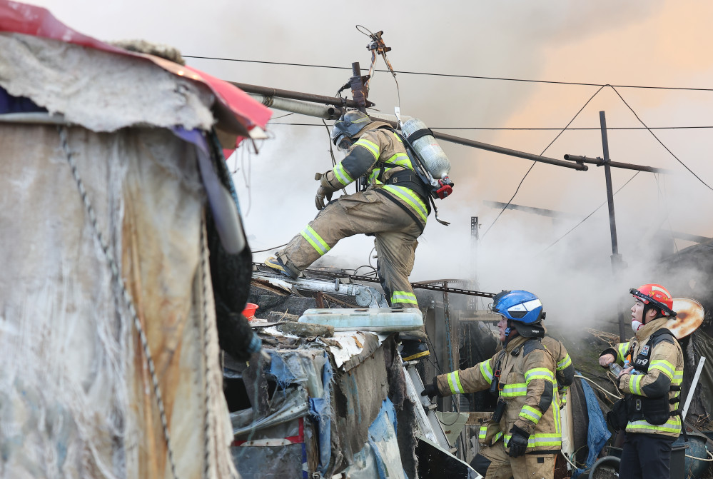 ▲16일 서울 강남구 개포동 구룡마을에서 소방관들이 잔불을 진압하고 있다.  (연합뉴스)