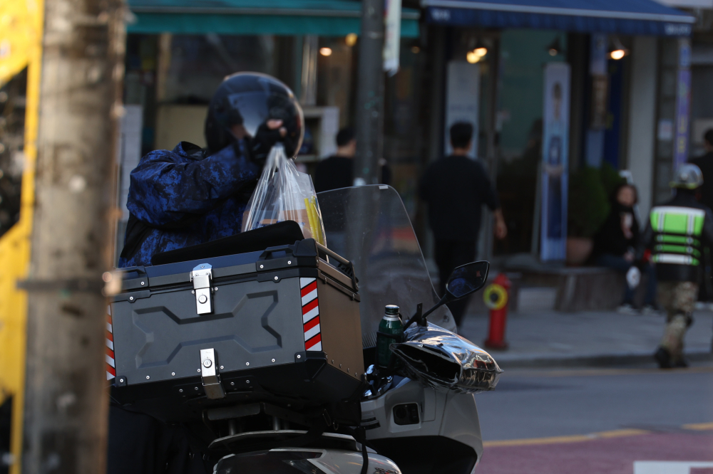 ▲서울 시내의 한 음식점 앞에서 배달기사가 오토바이 짐칸에 배달 음식을 담고 있다. (고이란 기자 photoeran@)