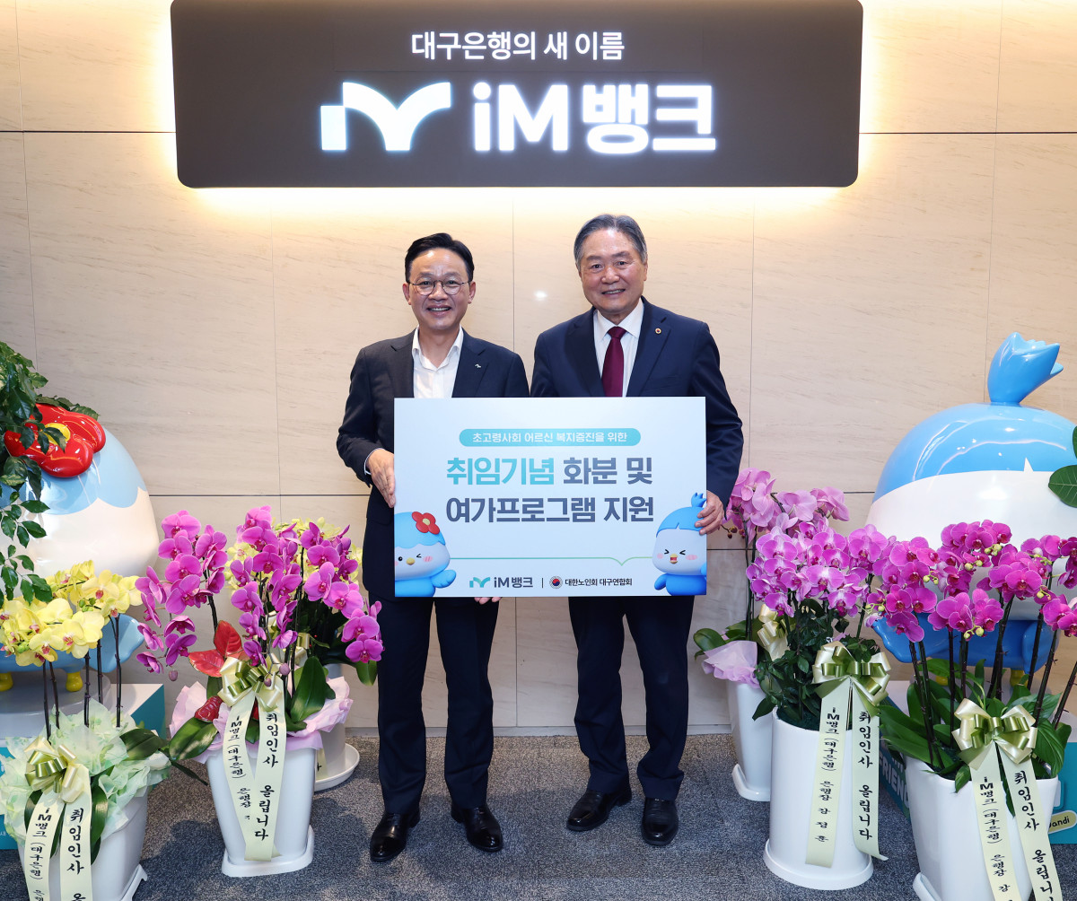 ▲강정훈(왼쪽) iM뱅크 은행장이 이종익 대한노인회 대구연합회 회장에게 16일 기부금과 난을 전달하고, 기념사진을 촬영하고있다.  (사진제공=iM뱅크)