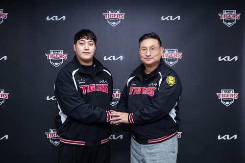 ▲불펜 투수 조상우(왼쪽)가 21일 광주 기아챔피언스필드에서 원소속팀인 프로야구 KIA 타이거즈와 자유계약선수(FA) 계약을 맺은 뒤 심재학 KIA 단장과 악수하고 있다. (사진제공=KIA 타이거즈)