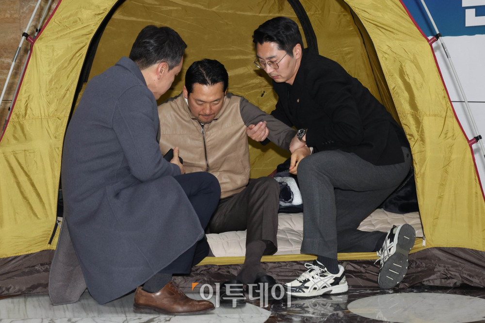 ▲통일교·공천헌금 '쌍특검' 수용을 요구하며 단식 일주일째를 맞은 장동혁 국민의힘 대표가 21일 서울 여의도 국회 로텐더홀 단식 농성장에서 의원들의 부축을 받고 있다. 고이란 기자 photoeran@