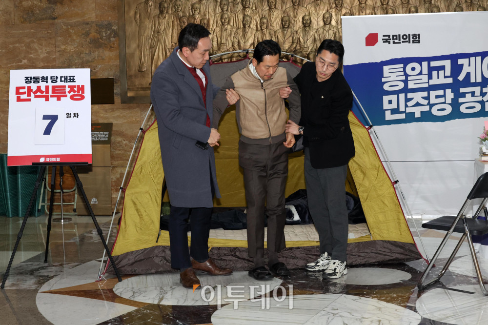 ▲통일교·공천헌금 '쌍특검' 수용을 요구하며 단식 일주일째를 맞은 장동혁 국민의힘 대표가 21일 서울 여의도 국회 로텐더홀 단식 농성장에서 의원들의 부축을 받고 있다. 고이란 기자 photoeran@