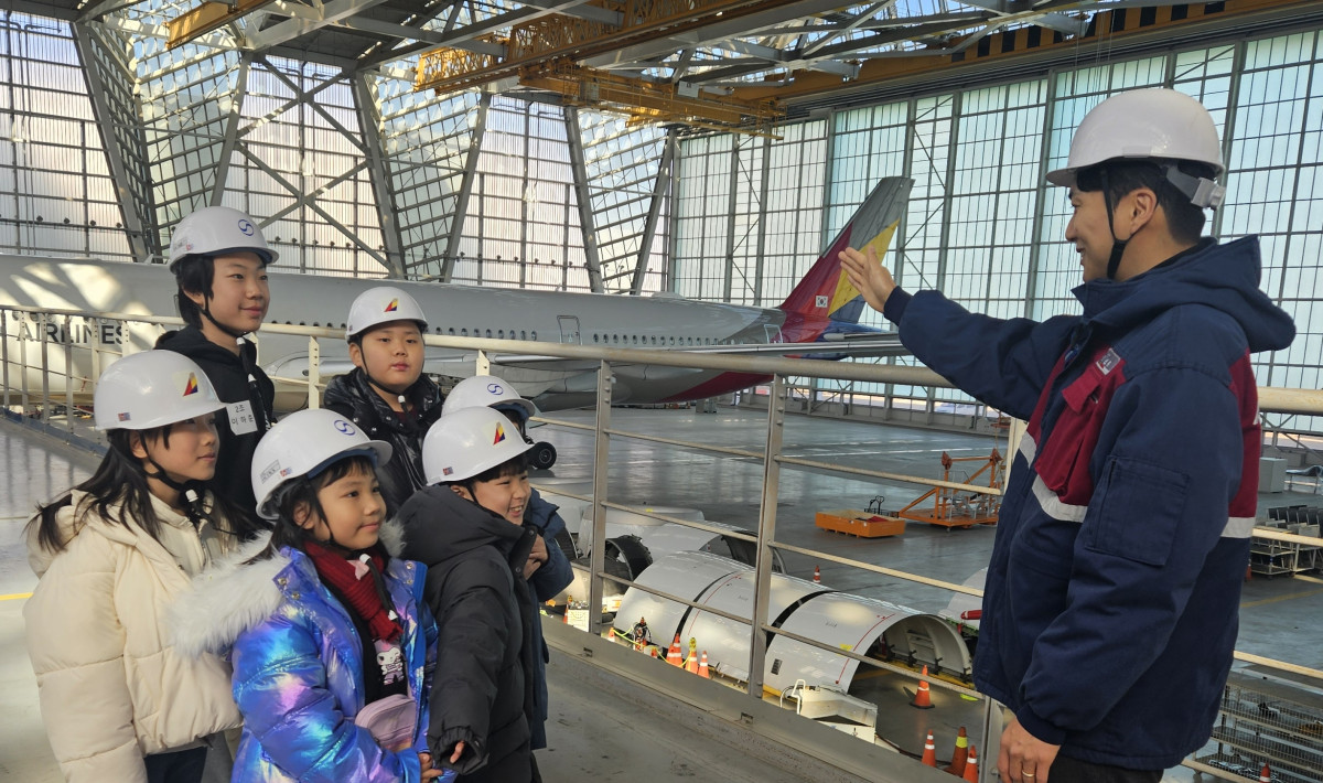 ▲인천국제공항 아시아나항공 정비 격납고에서 ‘Why? 항공과학 탐험교실’ 행사에 참가한 아시아나항공·대한항공 직원 자녀들에게 현직 정비사가 항공기에 대해 설명하고 있다. (사진=아시아나항공)