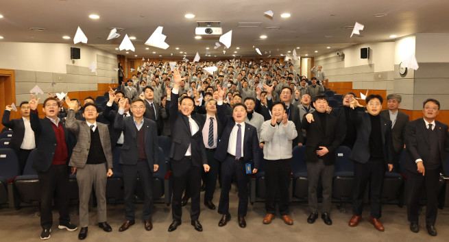 ▲윤진오 동부건설 대표(첫째줄 왼쪽 네번째)를 비롯한 임직원들이 회사 발전을 염원하는 종이비행기 날리기 퍼포먼스를 하고 있다. (사진제공=동부건설)