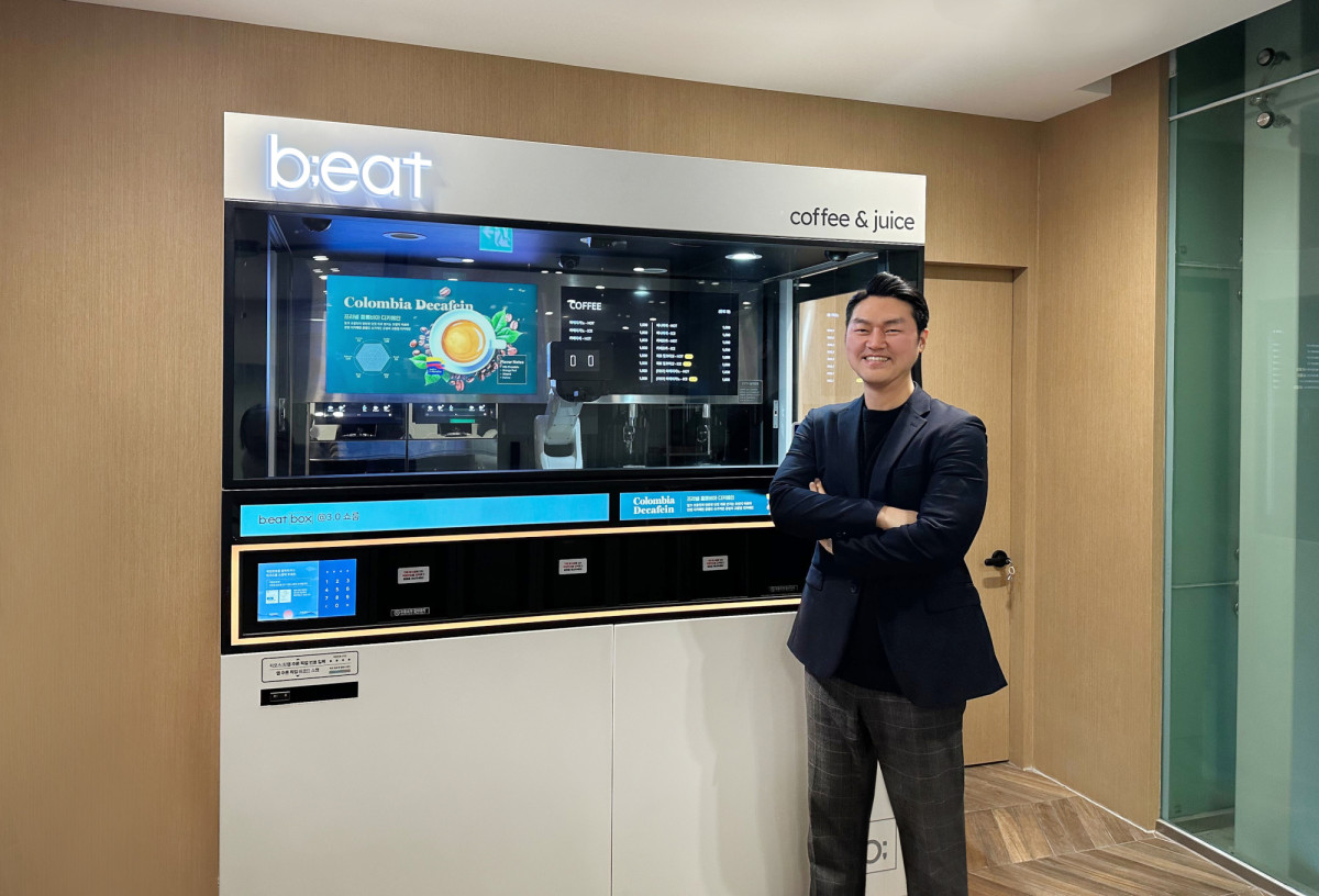 ▲채윤관 비트코퍼레이션 대표가 로봇커피 ‘비트(b;eat)’ 앞에서 포즈를 취하고 있다.(다날 제공)