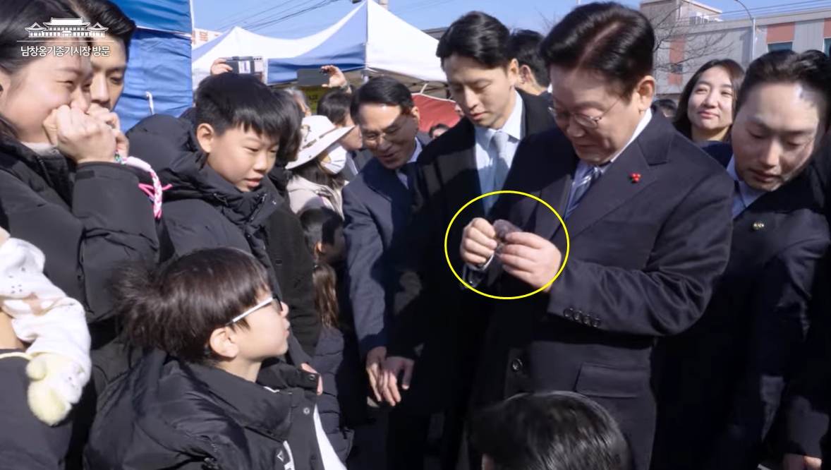 ▲이재명 대통령이 23일 울산의 남창옹기종기시장을 방문한 자리에서 한 아이로부터 '두쫀쿠'를 선물받았다. (출처=이재명 대통령 공식 유튜브 갈무리)