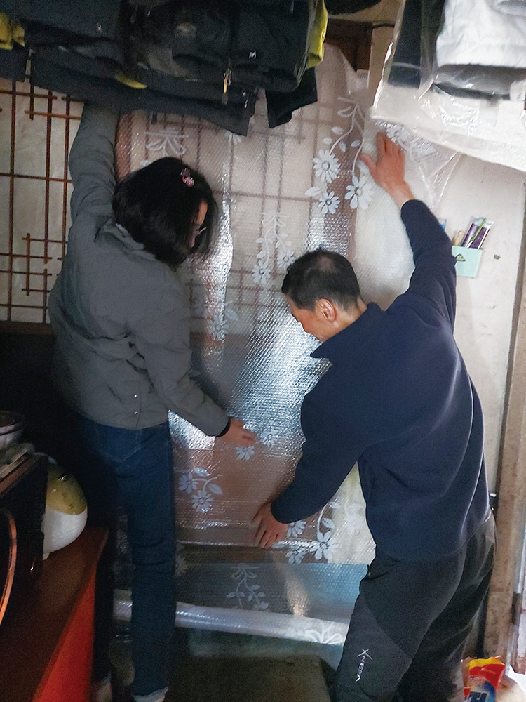 ▲류남희 생활지원사(왼쪽)가 대구 중구 성내2동에 있는 독거어르신 집을 방문해 한파 대비 문풍지를 붙이는 모습. (사진제공=류남희 생활지원사)