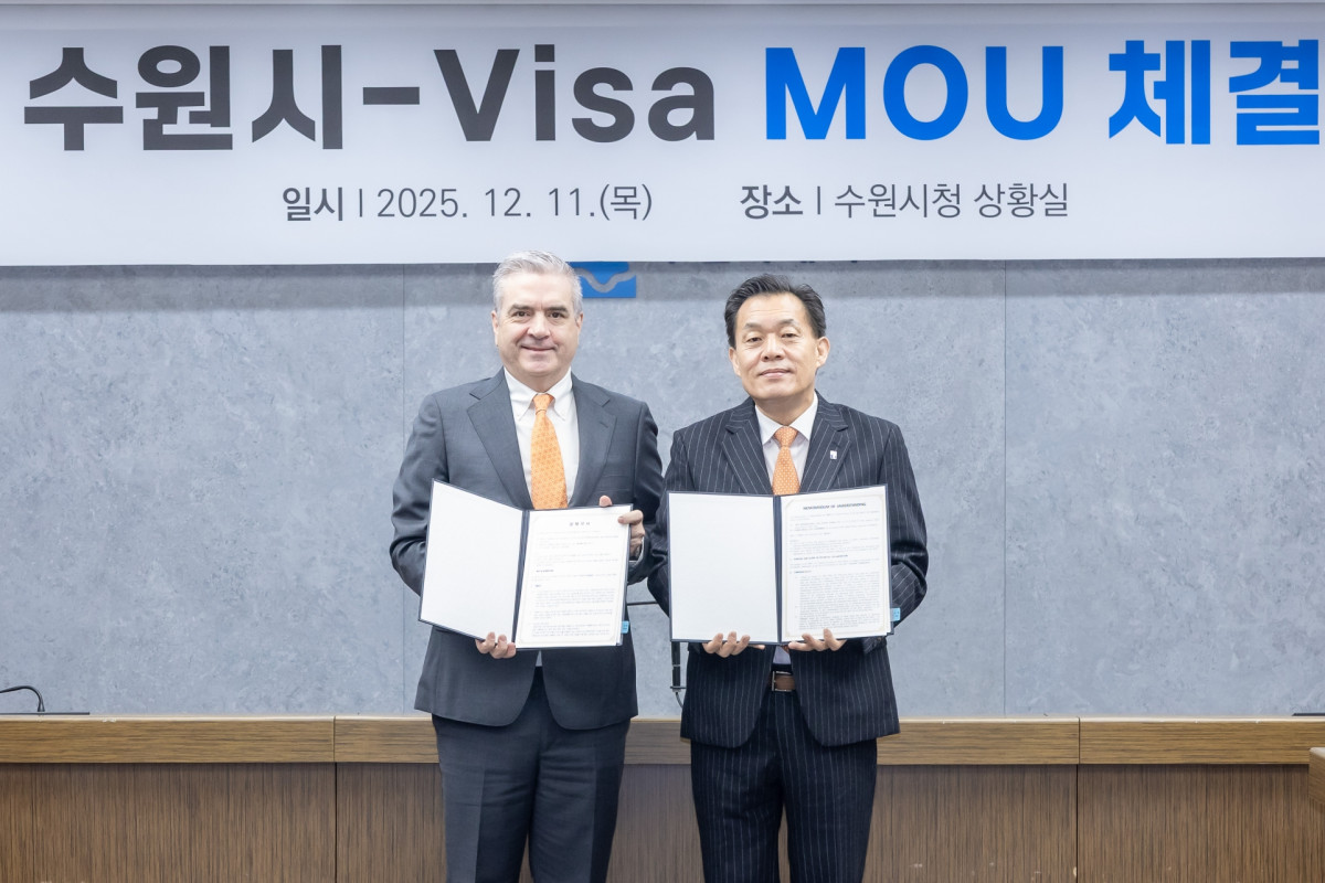 ▲이재준 수원시장(오른쪽)과 패트릭 스토리 비자 코리아 사장이 2025년 12월 11일 수원시청 상황실에서 전국 지자체 최초 중소기업 수출결제 간소화 협약을 체결한 뒤 협약서를 들어 보이고 있다. (수원특례시)