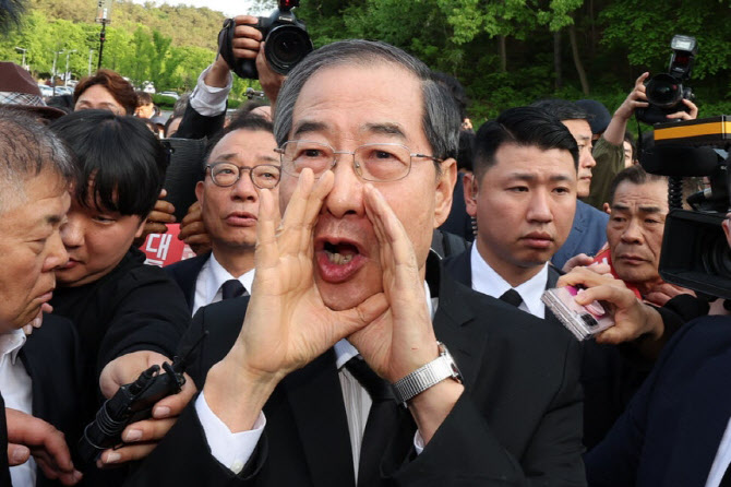 ▲지난해 5월 광주 북구 국립 5·18 민주묘지를 찾은 한덕수 전 총리가 광주비상행동 등 시민·사회단체 관계자들의 반발에 가로 막히자 "저도 호남 사람"이라며 참배를 호소하고 있다.
 (사진제공=연합뉴스)