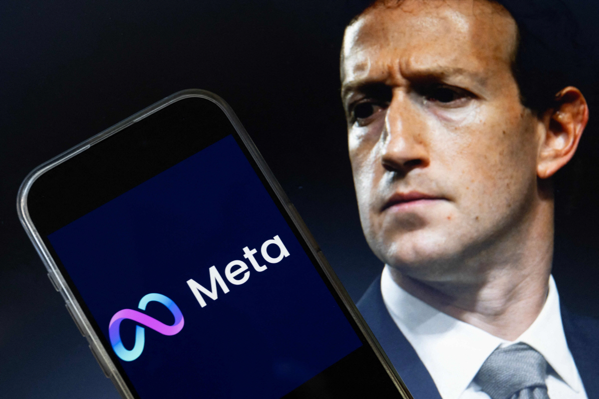 ▲메타 로고가 담긴 휴대폰 너머로 마크 저커버그 최고경영자(CEO) 모습이 보인다. AFP연합뉴스