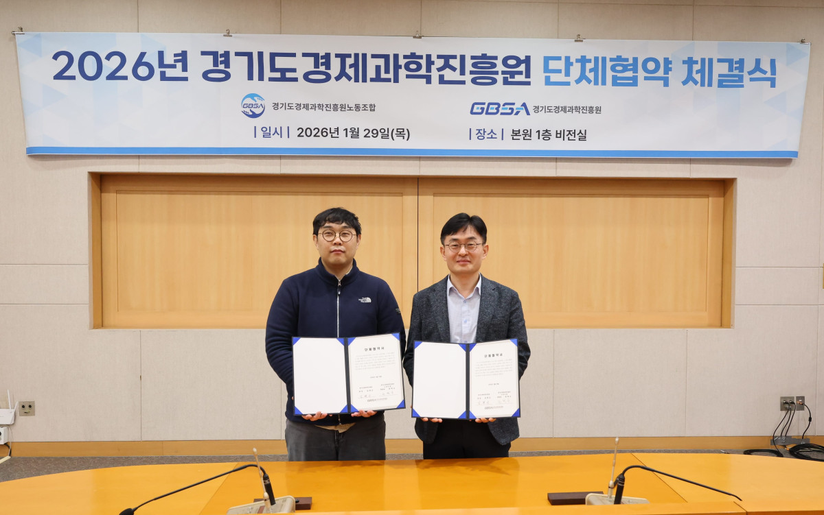 ▲김현곤 경기도경제과학진흥원장(오른쪽)과 권혁규 노동조합 위원장이 29일 본원 1층 비전실에서 '2026년도 단체협약'을 체결한 뒤 협약서를 들어 보이고 있다. (경기도경제과학진흥원)