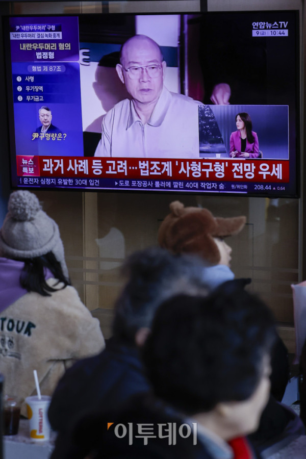 ▲'내란 우두머리 혐의'를 받는 윤석열 전 대통령에 대한 결심공판이 열린 9일 서울 용산구 서울역에서 시민들이 결심공판 관련 뉴스를 시청하고 있다. 조현호 기자 hyunho@