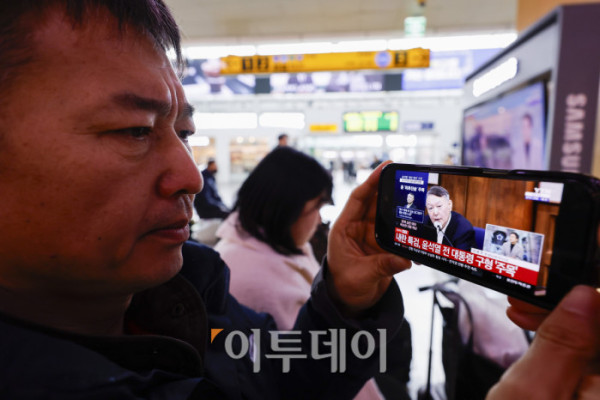 ▲'내란 우두머리 혐의'를 받는 윤석열 전 대통령에 대한 결심공판이 열린 9일 서울 용산구 서울역에서 시민들이 결심공판 관련 뉴스를 시청하고 있다. 조현호 기자 hyunho@