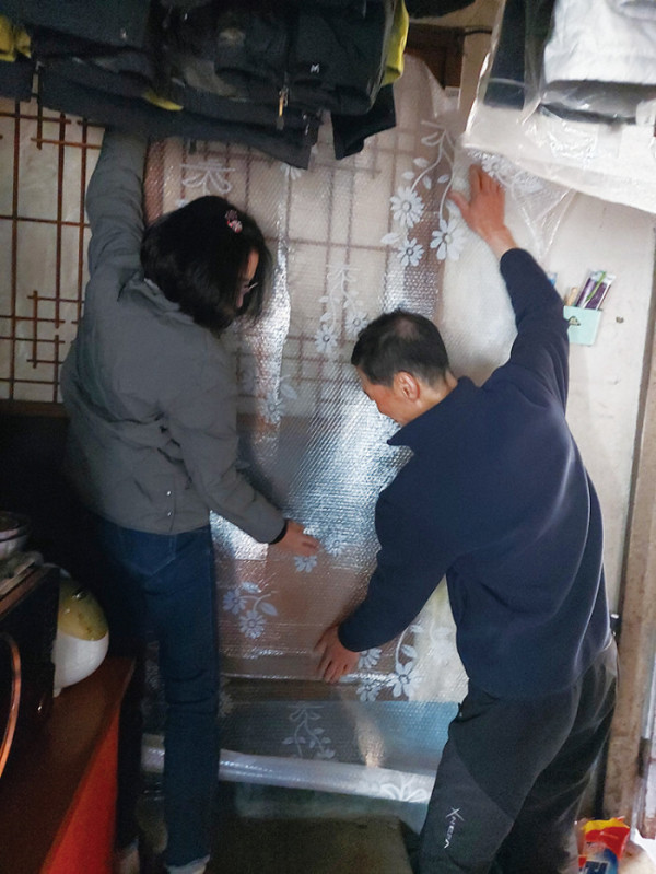 ▲류남희 생활지원사(왼쪽)가 대구 중구 성내2동에 있는 독거어르신 집을 방문해 한파 대비 문풍지를 붙이는 모습. (사진제공=류남희 생활지원사)