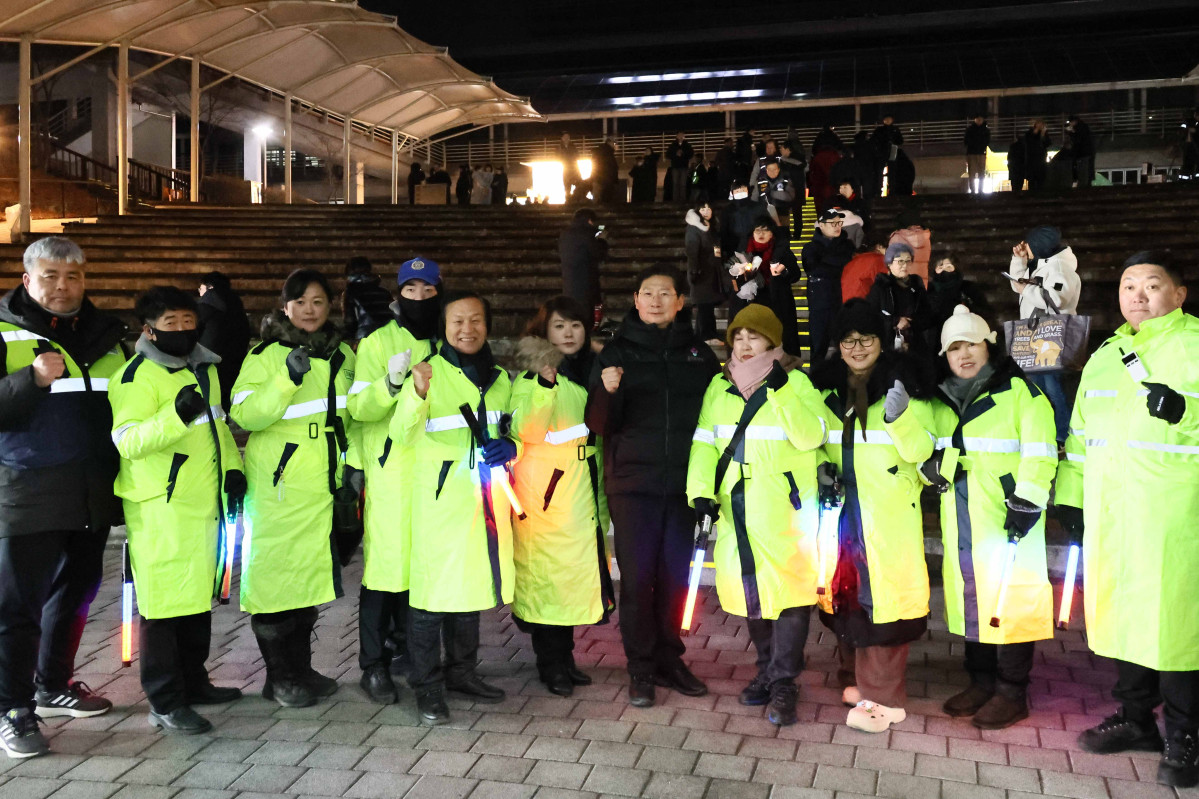 ▲이상일 용인특례시장(가운데)이 31일 밤 시청 야외음악당에서 열린 '용인반도체 국가산단 사수 촛불문화제'에서 형광 조끼를 입은 안전관리 요원들과 함께 파이팅을 외치고 있다. 이 시장은 안전사고에 즉각 대처하기 위해 2시간 동안 진행된 행사가 종료될 때까지 현장을 지켰다. (용인특례시)