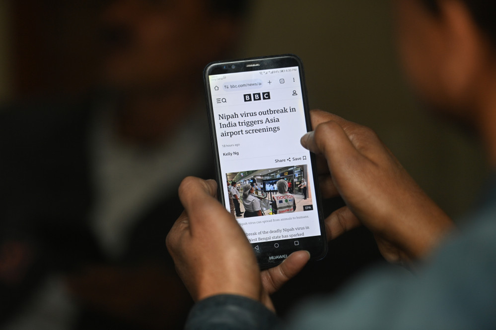 ▲파키스탄 카라치에서 한 남성이 28일(현지시간) 인도 웨스트벵골주에서 보고된 니파 바이러스 감염 사례와 관련한 뉴스 알림을 스마트폰으로 확인하고 있다. 인도 보건당국은 이달 들어 치명적인 인수공통감염병인 니파 바이러스 확진 사례 2건을 공식 확인했으며, 추가 확산을 막기 위해 약 200명에 대한 접촉자 추적과 함께 ‘적시 차단(timely containment)’ 조치를 진행 중이라고 밝혔다. (EPA/연합뉴스)