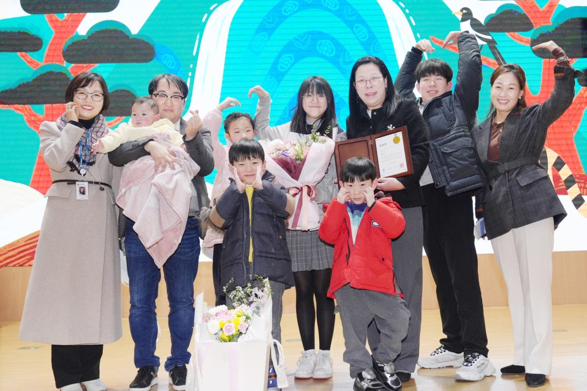 ▲이혜련 씨(오른쪽 세 번째)가 6남매, 남편과 함께 수원시장 표창을 받은 뒤 기념촬영을 하고 있다. 김은주 수원시 여성가족국장, 석은숙 가족정책과장이 함께했다. 고등학교 1학년 큰딸부터 9개월 막내까지 여덟 식구가 한자리에 모여 만든 하트 손동작이 저출산 시대 희망의 메시지를 전하고 있다. (수원특례시)