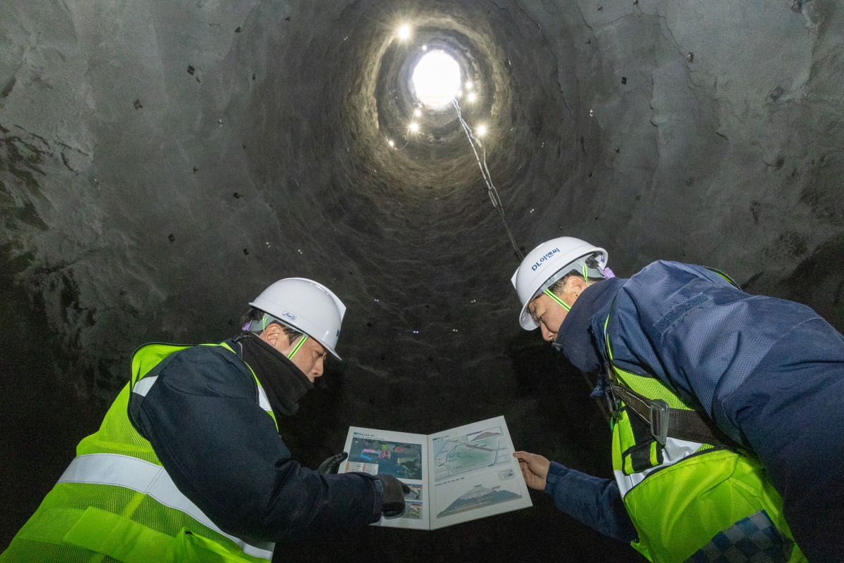 ▲부산항 신항 북측 컨테이너부두 2단계 항만배후단지 조성 공사 현장 수직터널 내부에서 DL이앤씨 관계자가 굴착 작업을 지휘하고 있다. (사진제공=DL이앤씨)