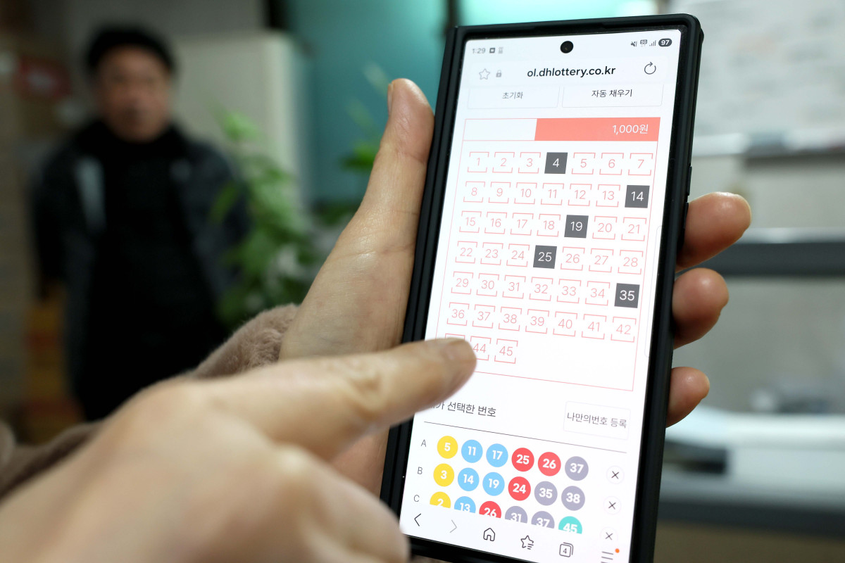 ▲복권 판매점이나 PC를 통해서만 가능했던 로또 구매가 모바일로 확대된 9일 서울의 한 사무실에서 자영업자가 스마트폰으로 로또를 구매하고 있다. 로또는 스마트폰에서 회원 가입 후 예치금을 충전해 살 수 있다. 판매 시간은 월요일 오전 6시부터 금요일 자정까지이며, 1인당 구매 한도는 PC와 모바일을 합쳐 회차당 5000원으로 제한된다. 신태현 기자 holjjak@
