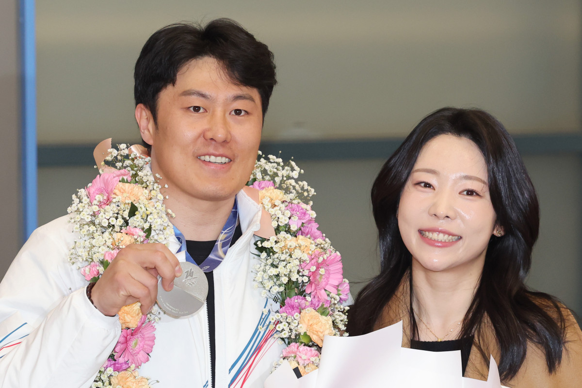 ▲2026 밀라노·코르티나담페초 동계 올림픽 스노보드 남자 평행대회전에서 은메달을 차지한 김상겸이 10일 인천국제공항을 통해 귀국해 아내와 기념촬영을 하고 있다. (연합뉴스)