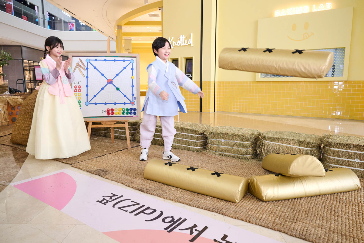 ▲스타필드 하남에서 진행 중인 ‘짚(ZIP)에서 놀자’ 팝업 전시(2/12~2/18)에서 어린이 모델들이 윷놀이를 하고 있다. (사진제공=신세계프라퍼티)
