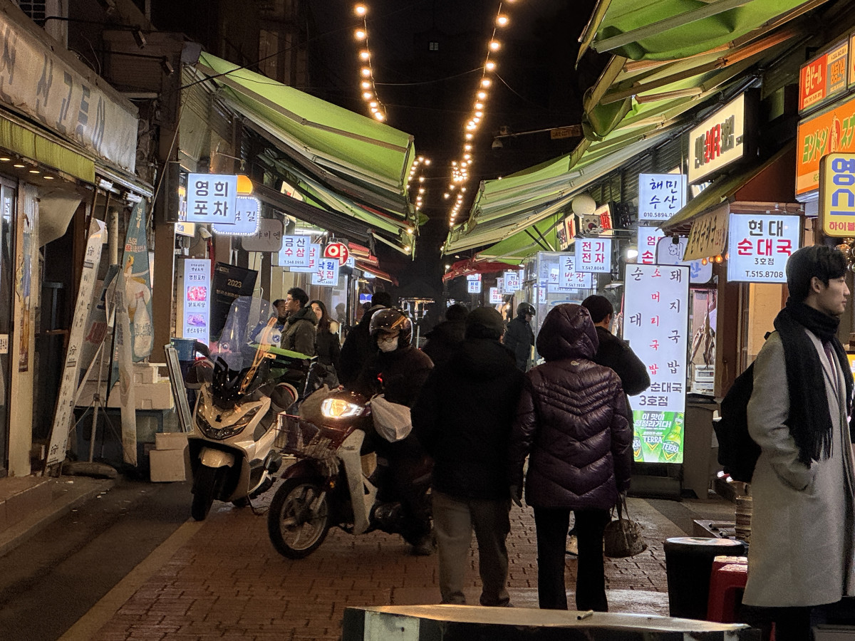 ▲서울 강남구 영동전통시장 저녁 시간, 전구 조명이 켜진 상점들 사이로 사람들과 오토바이가 오가고 있다. (박상군 인턴 기자 kopsg@)