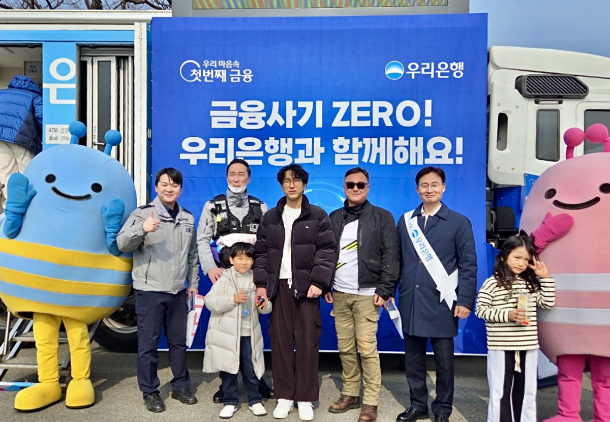 ▲정철경 우리은행 채널전략부장(오른쪽 두 번째)과 천안서북경찰서 경찰관이 13일 경부고속도로 하행선 망향휴게소에서 귀성객과 기념사진을 촬영하고 있다. (사진제공=우리은행)