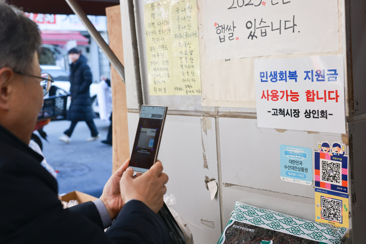 ▲장인홍 구로구청장이 고척 전통 시장 내 한 상점에서 구로 사랑 상품권으로 결제하고 있다. (사진 제공 = 구로구)
