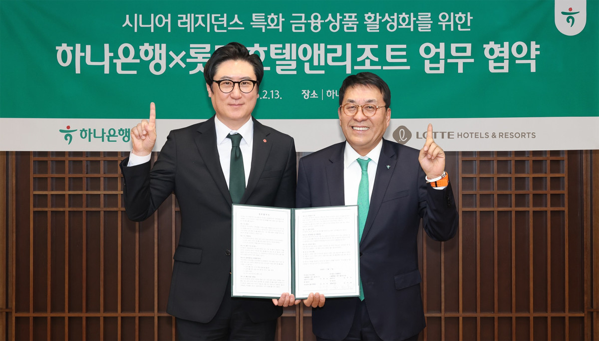 ▲13일 김진우 하나은행 자산관리그룹 부행장(오른쪽)이 김지태 롯데호텔앤리조트 개발본부장과 협약서를 들고 기념촬영을 하고 있다. (사진제공 = 하나은행)