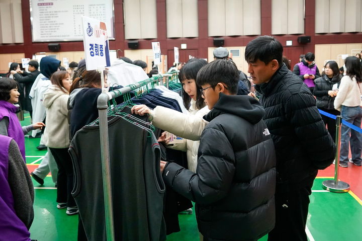 ▲교복을 고르고 있는 가족. 사진은 기사와 직접적인 관계가 없음 (뉴시스)