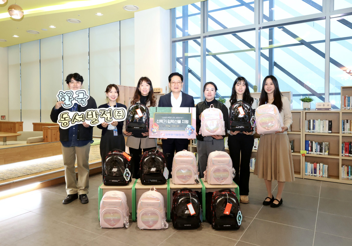 ▲권명호 한국동서발전 사장(가운데) 및 직원들이 새학기 책가방 꾸러미를 들고 기념사진을 찍고 있다. (사진제공=한국동부발전)