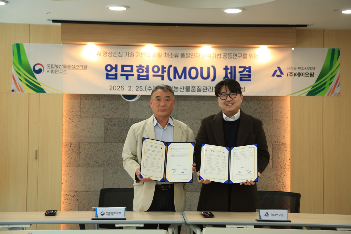 ▲조경규 국립농산물품질관리원 시험연구소장(왼쪽)이 25일 경북 김천 본원에서 곽호재 에이오판 대표이사와 공동연구를 위한 업무협약을 체결한 후 기념 촬영을 하고 있다. (사진제공=농림축산식품부)