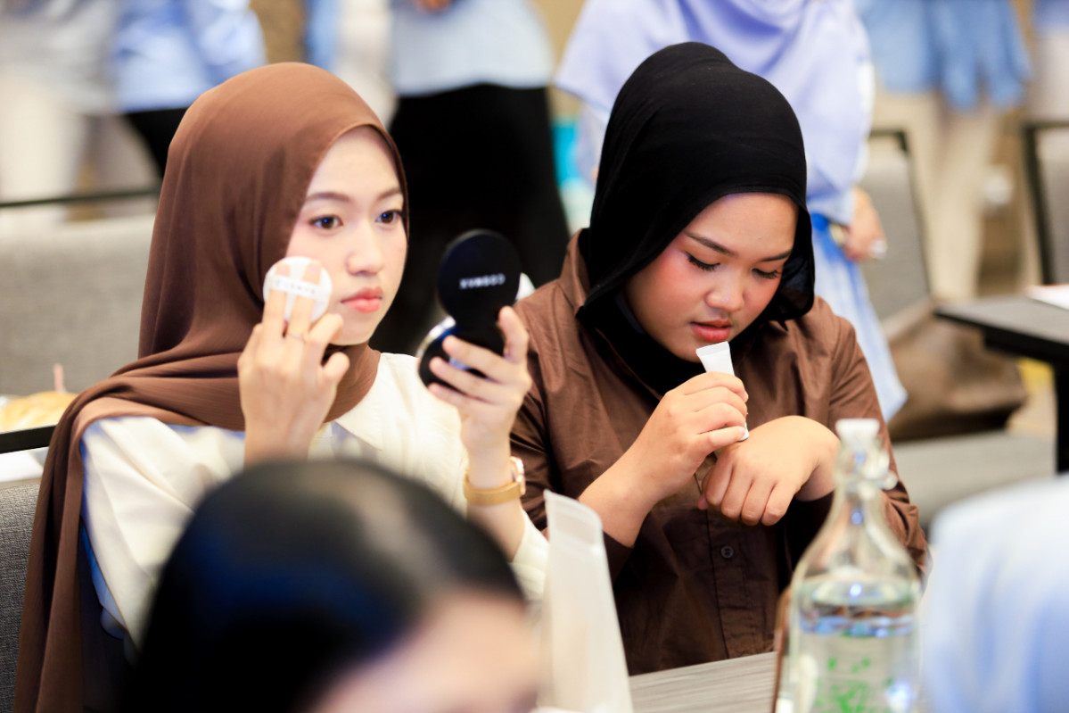 ▲13일 인도네시아 자카르타에서 개최된 ‘코스맥스 이노베이션 콘퍼런스 2026’ 행사장에서 현지 고객사 관계자들이 코스맥스 연구개발 제품을 사용하고 있다. (사진제공=코스맥스)