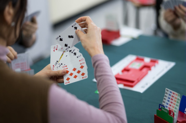 ▲브리지 대회에 참가한 회원이 카드를 들고 패를 읽고 있다. 조용한 집중 속에서 판단과 추론이 오가는 경기 특유의 긴장감이 현장에 흐른다.(이준호 기자)