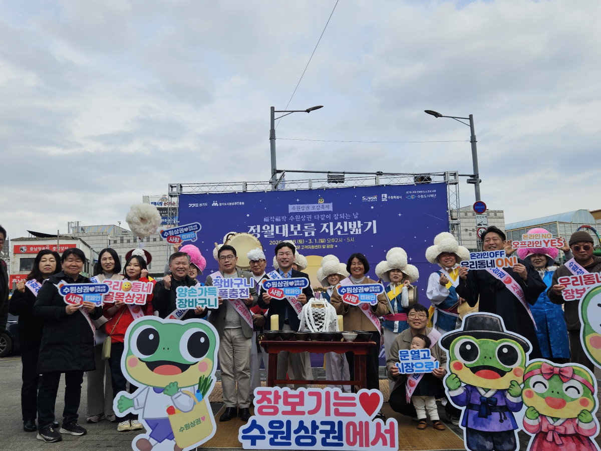 ▲수원도시재단이 정월대보름을 앞두고 수원남문시장 지동교 일대에서 개최한 '복작복작 수원상권, 다 같이 잘되는 날' 지신밟기 행사에서 참가자들이 '장보기는 수원상권에서' 피켓을 들고 환하게 웃으며 기념촬영을 하고 있다. 영수증 인증 체험 400여 건, 이틀간 2000여 명 방문이라는 실질적 성과로 구도심 전통시장 상권 활성화의 새로운 모델을 제시했다는 평가를 받았다. (수원도시재단)