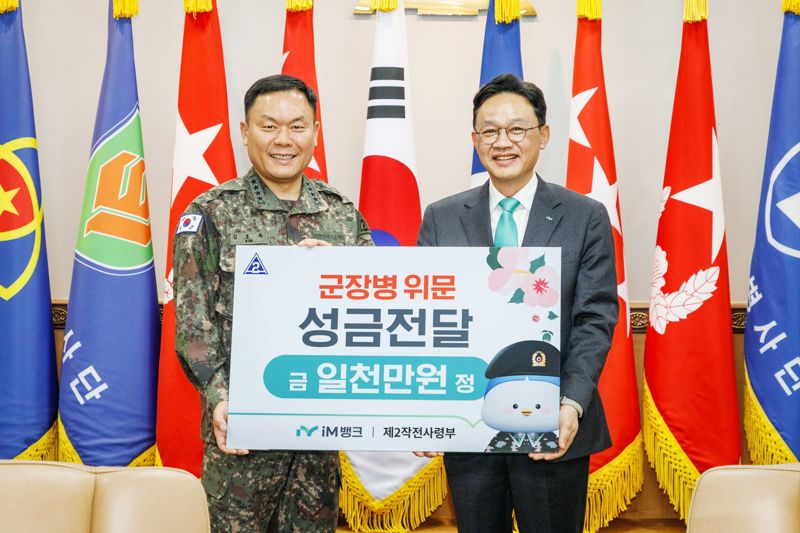 ▲강정훈 iM뱅크 은행장(오른쪽)은 대구 수성구에 위치한 육군 제2작전사령부를 방문해 국토방위에 헌신하고 있는 장병 격려를 위한 위문성금 1000만원을 전달하고 김호복 사령관과 함께 기념촬영을 하고 있다. (iM뱅크)