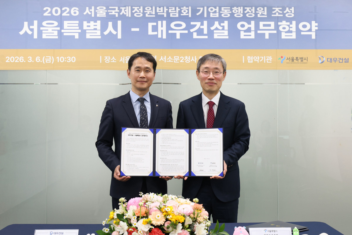 ▲김용현 건축사업본부 상무(왼쪽)와 김영환 서울시 정원도시국장이 업무협약식 체결 후 기념촬영을 하고 있다. (대우건설 제공)
