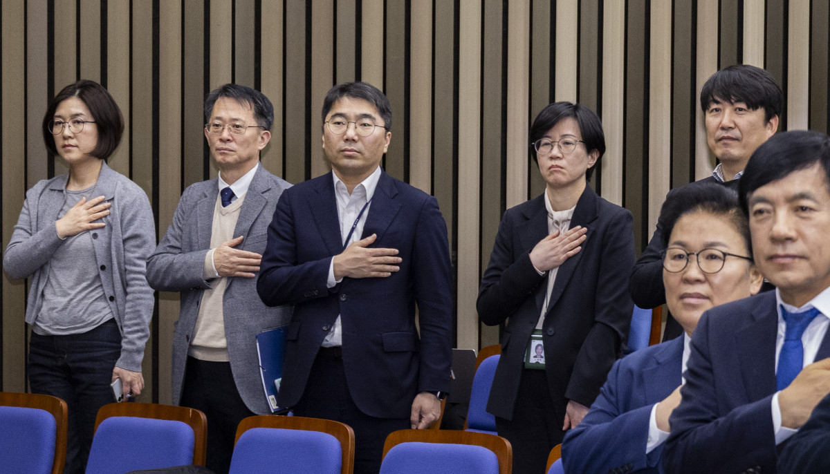 ▲5일 국회에서 열린 더불어민주당 정책 의원총회에 공소청법·중수청법에 대한 정부안을 설명하기 위해 국무총리실 산하 검찰개혁추진단 관계자들이 국기에 경례하고 있다. (연합뉴스)