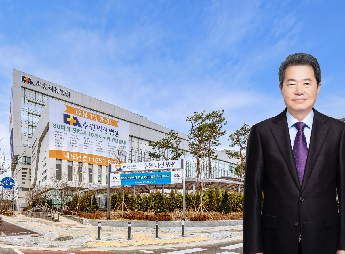 ▲강병직 덕산의료재단 이사장이 지하 4층·지상 9층·연면적 약 10만㎡ 규모의 수원덕산병원 전경을 배경으로 서 있다. 수원덕산병원은 3월 7일 개원식을 열고 서수원 지역 의료공백 해소와 경기 남부권 의료 거점병원으로의 도약을 공식 선언했다. (수원덕산병원)