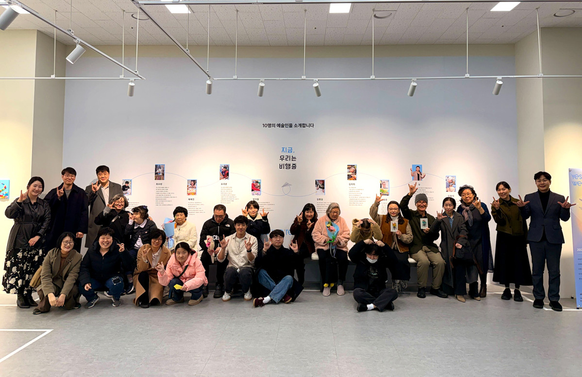 ▲에어프레미아 소속 장애예술단 작가들이 행사장에서 참석자들과 함께 기념촬영을 진행하고 있다. (자료제공=에어프레미아)