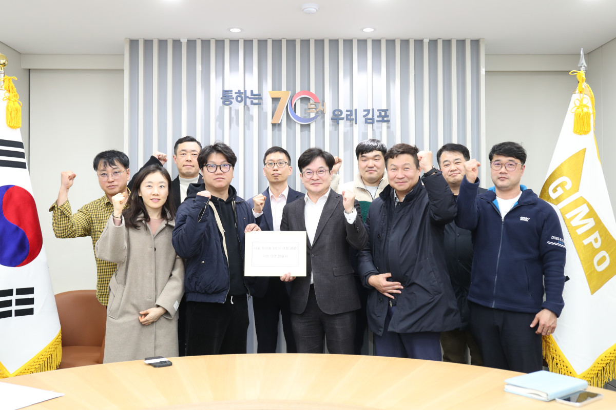 ▲김병수 김포시장(가운데)이 3월 3일 시청 회의실에서 서울 5호선 국회 국민청원을 이끈 시민 대표들과 함께 주먹을 쥐며 결의를 다지고 있다. (김포시)