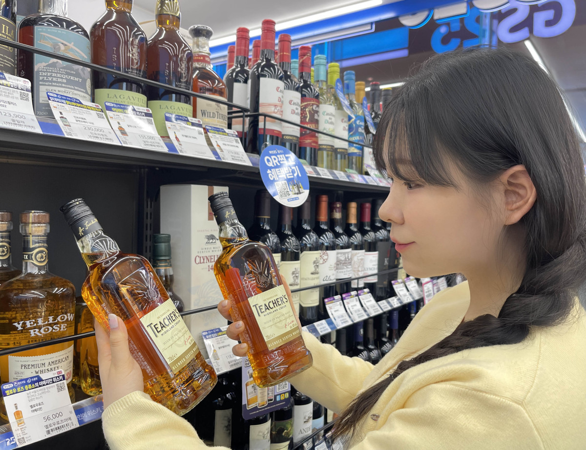 ▲GS25에서 모델이 가성비 위스키 티처스를 살펴보고 있다. (사진제공=GS리테일)