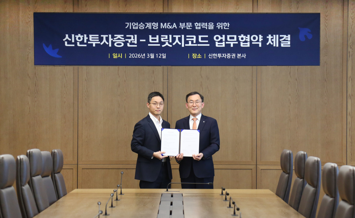 ▲정근수 신한투자증권 CIB총괄사장(사진 오른쪽)이 박상민 브릿지코드 대표와 함께 여의도 신한투자증권 본사에서 열린 MOU 체결식을 기념해 사진 촬영을 하고 있다. (사진=신한투자증권)