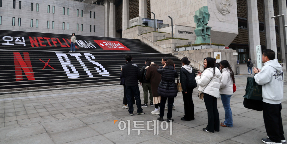 ▲방탄소년단(BTS) 컴백 공연을 앞두고 15일 서울 광화문 세종문화회관 계단에 설치된 BTS 홍보 광고에서 관광객과 시민들이 기념촬영을 하고 있다. 경찰과 서울시는 21일 약 26만 명이 몰릴 것으로 보고, 인파 밀집 사고 예방을 위해 주변 빌딩 31곳에 대한 출입 통제 등 안전 관리에 나설 예정이다. 고이란 기자 photoeran@