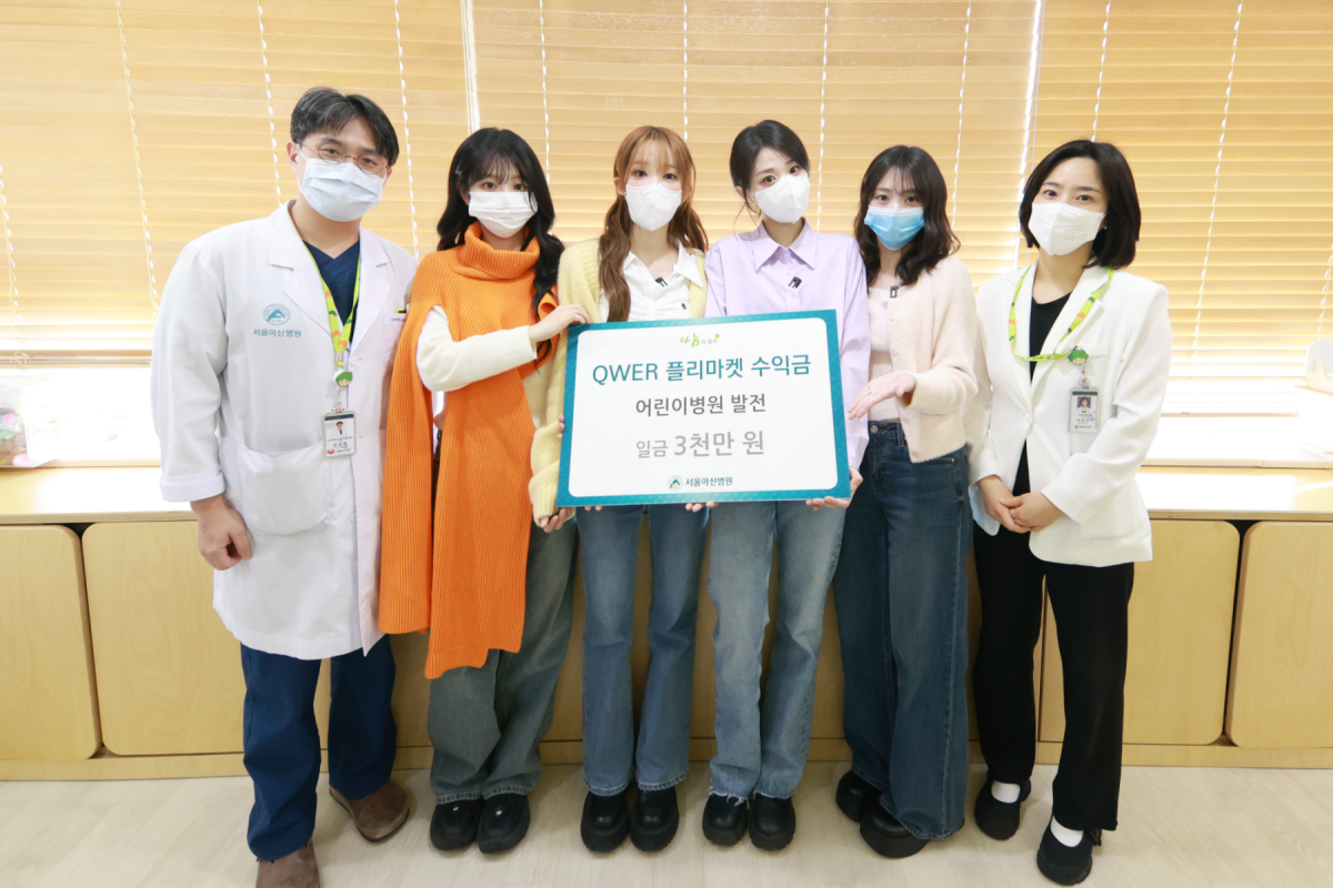 ▲강성한 서울아산병원 소아청소년종양혈액과 교수(왼쪽)를 비롯한 의료진이 QWER과 기념촬영을 하고 있다. (사진제공=서울아산병원)