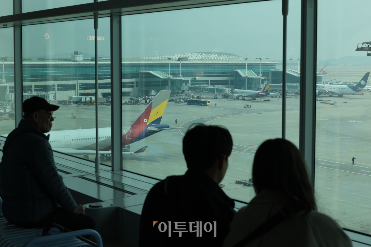 ▲중동 사태로 국제유가와 환율이 오르면서 4월 국제선 항공권에 부과되는 유류할증료가 전월보다 큰 폭으로 인상돼 여행객들의 항공권 부담이 커질 전망이다. 이에 따라 국내 항공사들은 다음 달 발권하는 항공권에 붙는 유류할증료를 최대 3배 이상 올릴 방침이다. 16일 인천국제공항 제2터미널 전망대에서 여행객들이 주기장을 보고 있다. 고이란 기자 photoeran@