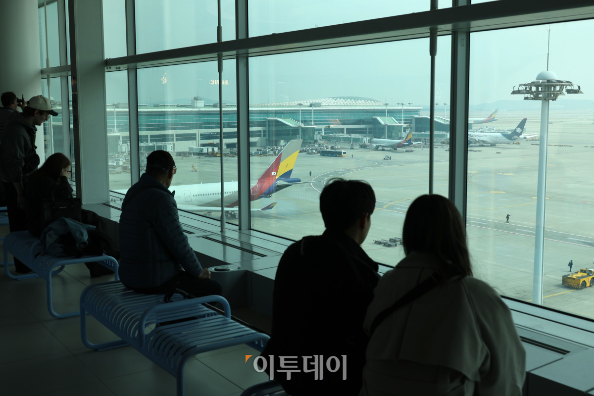 ▲중동 사태로 국제유가와 환율이 오르면서 4월 국제선 항공권에 부과되는 유류할증료가 전월보다 큰 폭으로 인상돼 여행객들의 항공권 부담이 커질 전망이다. 이에 따라 국내 항공사들은 다음 달 발권하는 항공권에 붙는 유류할증료를 최대 3배 이상 올릴 방침이다. 16일 인천국제공항 제2터미널 전망대에서 여행객들이 주기장을 보고 있다. 고이란 기자 photoeran@