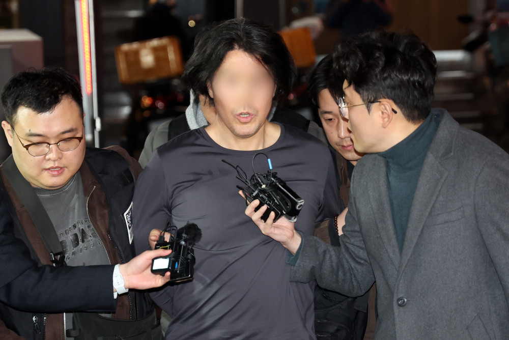 ▲부산에서 전 직장 동료인 항공사 기장을 흉기로 살해한 혐의를 받는 50대 A씨가 17일 부산 부산진경찰서로 압송되고 있다. (뉴시스)