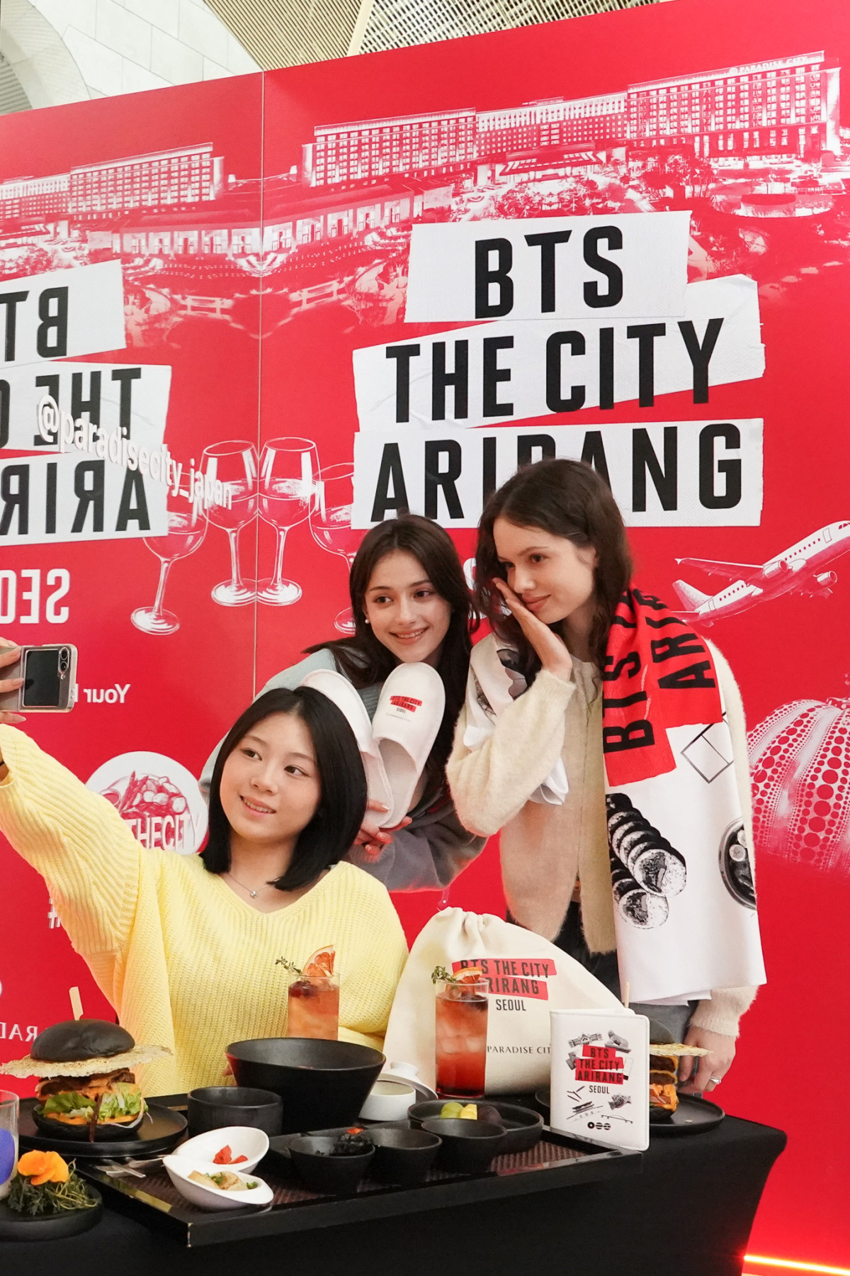 ▲인천 중구 파라다이스시티에 조성된 포토존에서 모델들이 방탄소년단 컴백을 기념하는 한정판 굿즈 5종과 '블랙버거' 등 식음료를 소개하고 있는 모습 (사진제공=파라다이스시티)